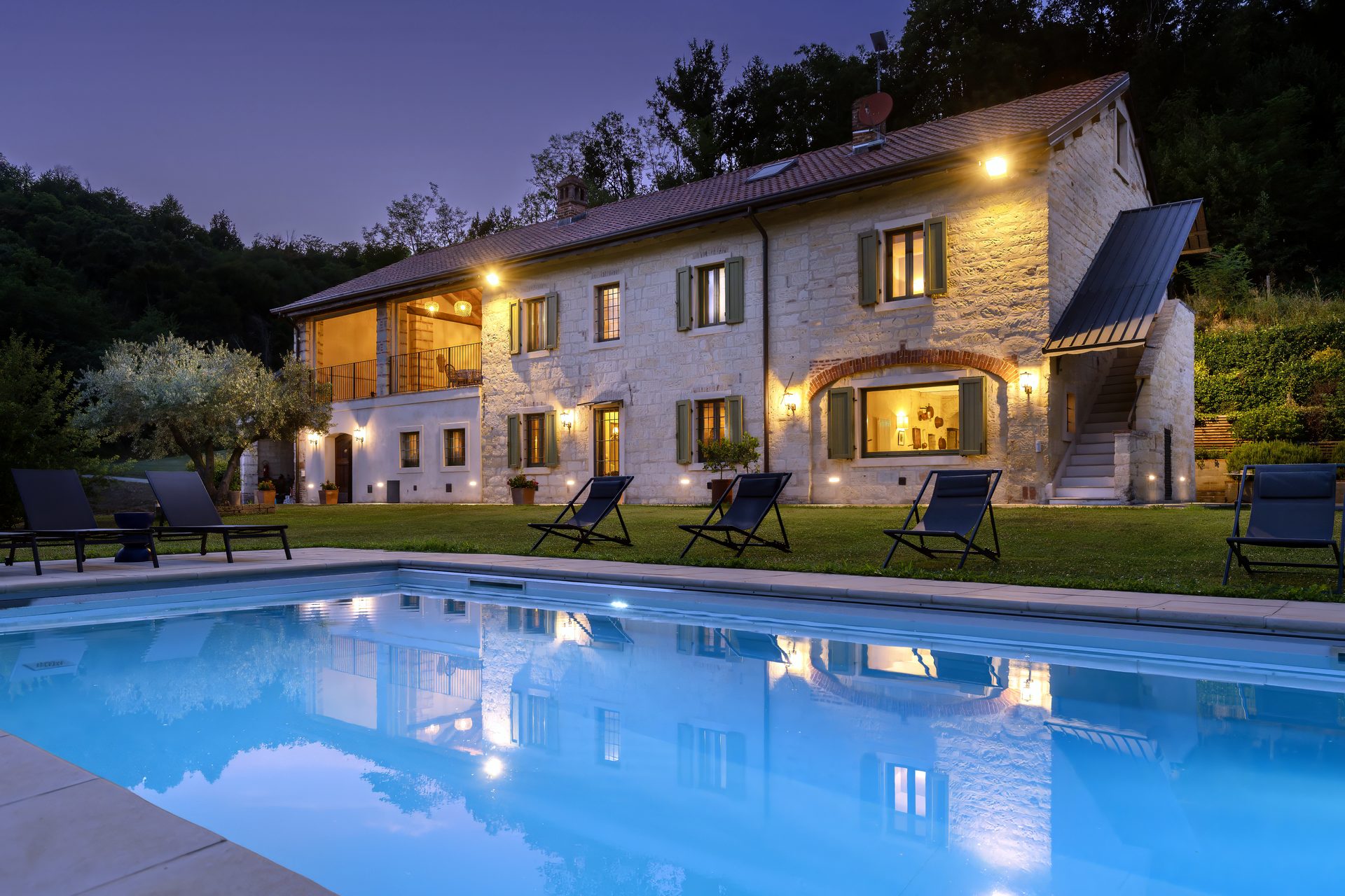 Villa Didiea at dusk: the pool and stone residence in Monferrato
